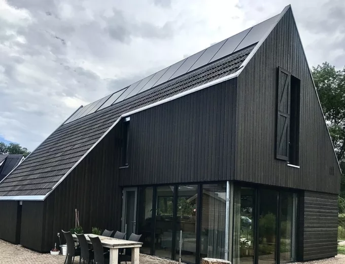 Vrijstaande woning in Enschede met zwarte houten gevel en zonnepanelen, gebouwd door Aannemersbedrijf Scholte op Reimer