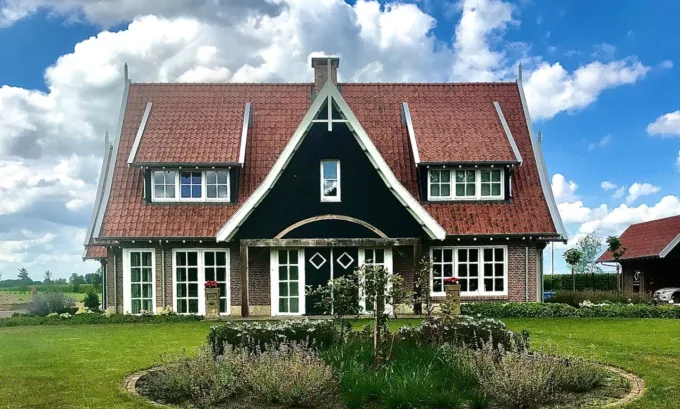 Woning met inwoning in Albergen met rode pannen en een zwarte houten topgevel, gebouwd door Aannemersbedrijf Scholte op Reimer